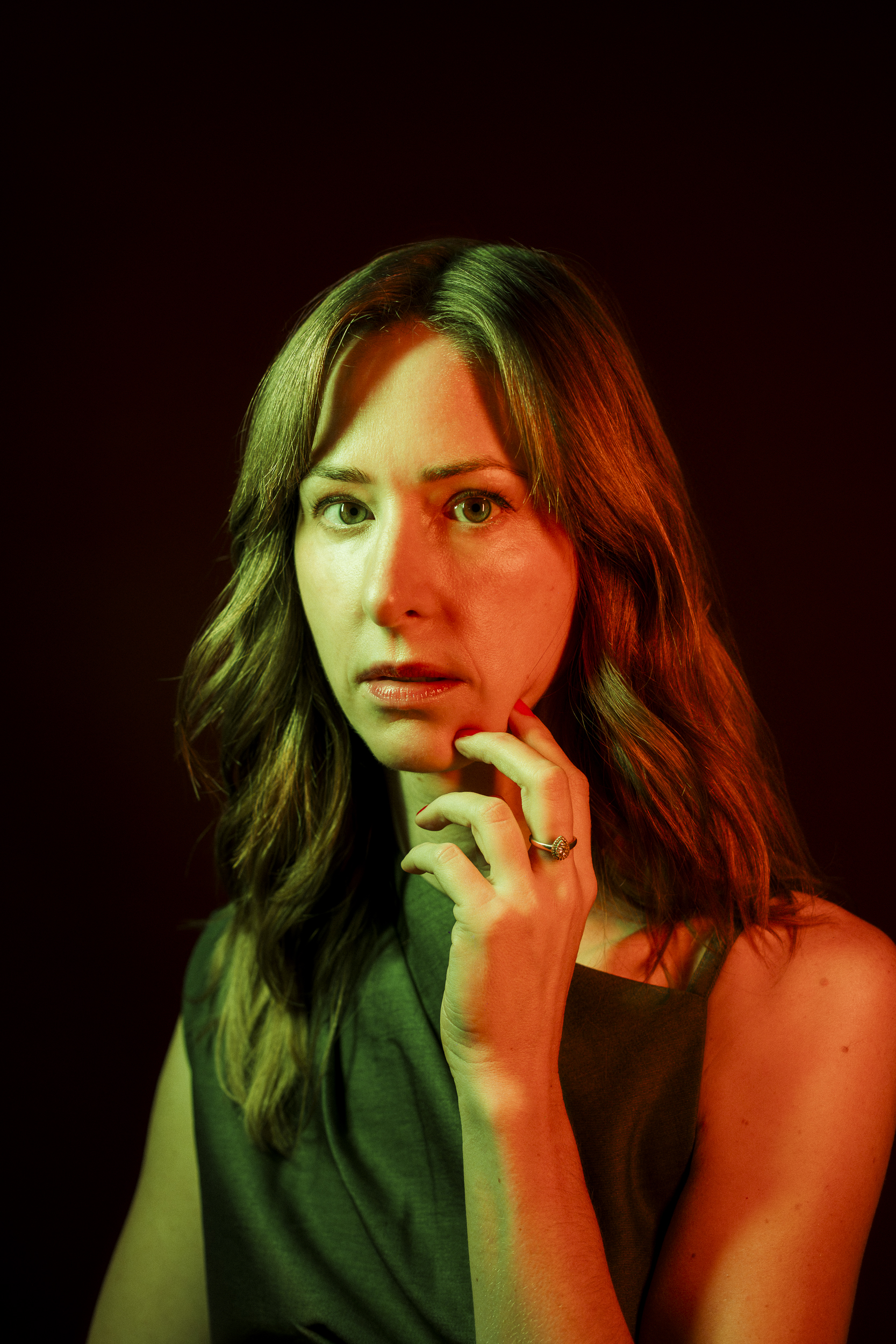 Portrait of Camille Brunette lit in warm red and green light